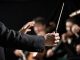Müziğin büyülü dünyasında izleyiciyi derinden etkileyen performansların arkasında çoğu zaman görünmeyen bir lider vardır: orkestra şefi. Sahnenin önünde, elindeki baton ile onlarca müzisyeni yöneten bu kişi, yalnızca ritim tutan biri değil, aynı zamanda müziğin ruhunu şekillendiren bir sanatçıdır. Klasik müzikten film müziklerine kadar geniş bir alanda görev alan orkestra şefi, sanat ve disiplinin birleştiği özel bir mesleği temsil eder. Konulu bir haber görseli.