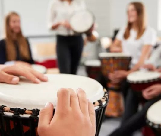 Müzik, tarih boyunca insanların duygularını ifade etmesinde ve sosyal etkileşimlerinde önemli bir rol oynamıştır. Bu alanda eğitim veren profesyonellerden biri olan ritim eğitmeni, bireylerin müziksel yeteneklerini geliştirmelerine yardımcı olur. Özellikle müzik okullarında, özel derslerde ve çeşitli kültürel etkinliklerde görev alan ritim eğitmeni, öğrencilerin ritim duygusunu güçlendiren temel figürlerden biridir. Konulu bir haber görseli.