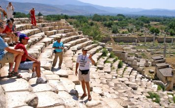 Turizm sektörü, ekonomik büyümenin ve kültürel etkileşimin önemli bir parçasıdır. Bu sektörün en kritik aktörlerinden biri olan turizm rehberi, turistlerin deneyimlerini en iyi şekilde yaşamasını sağlayan profesyonellerdir. Turizm rehberi, hem yerel kültürü hem de tarihi değerleri anlatmak, misafirlere rehberlik etmek ve güvenli bir seyahat deneyimi sunmakla sorumludur. Konulu bir haber görseli.